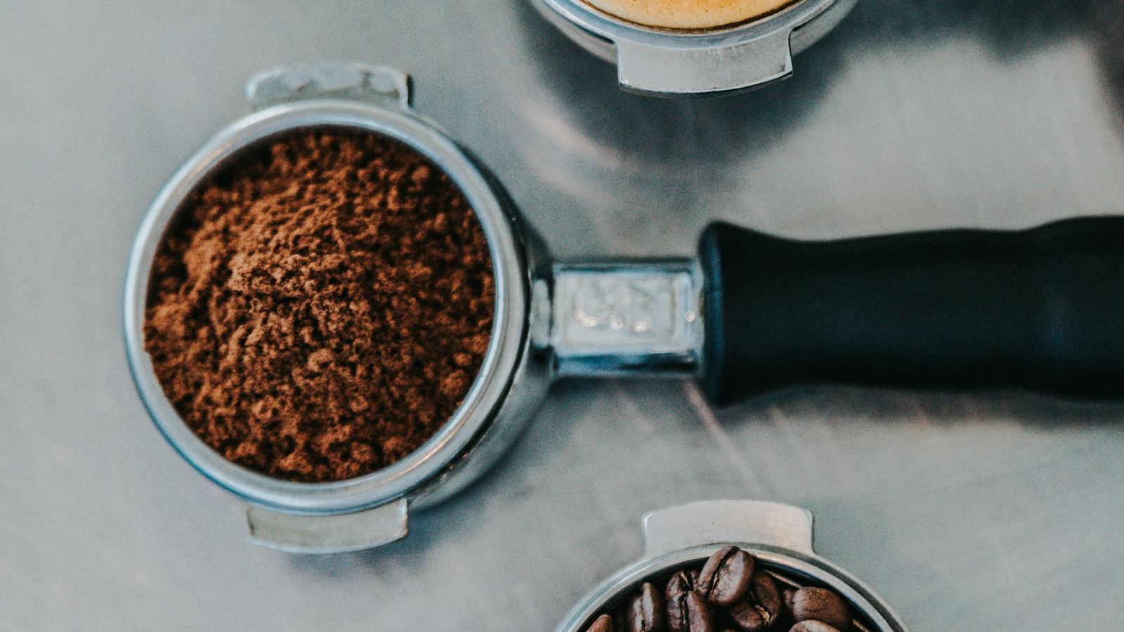 Overhead view of an espresso portafilter filled with fresh coffee grounds